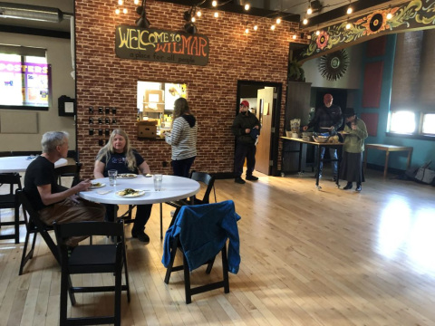Group of people standing and sitting in the WilMar Neighborhood Center