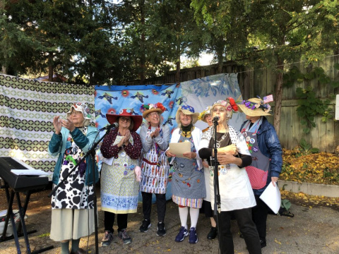 People in hats outside performing and supporting each other.