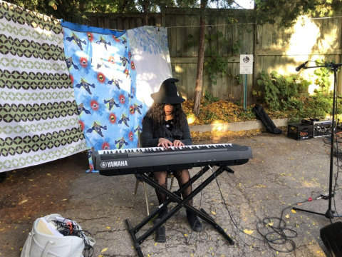 Person in front of curtains outdorrs playing te keyboard